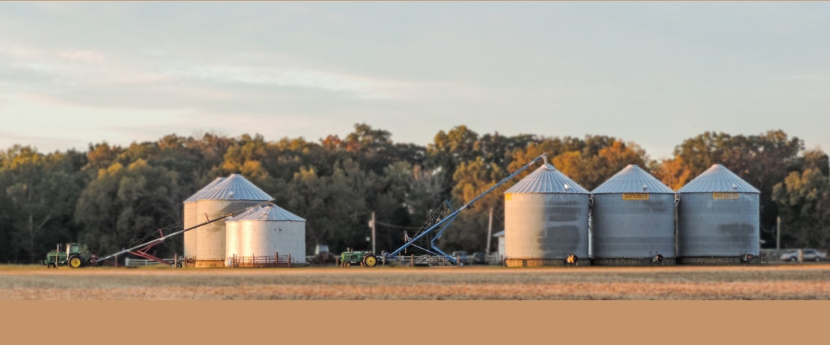 farm scene with grain bins and combine