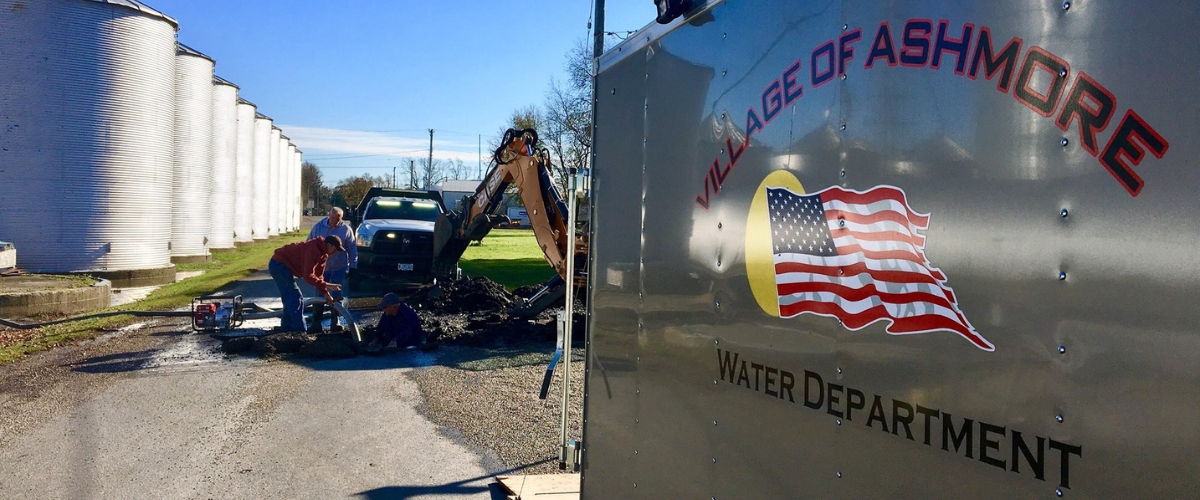 the side of the water utility trailer with men working in the background